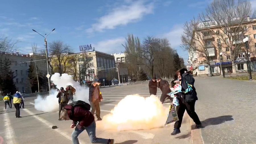 Demonstrators react to stun grenades thrown by Russian troops as they protest the Russian invasion, along Ushakova Avenue in Kherson, Ukraine March 21, 2022 in this still image from video obtained by REUTERS THIS IMAGE HAS BEEN SUPPLIED BY A THIRD PARTY. NO RESALES. NO ARCHIVES