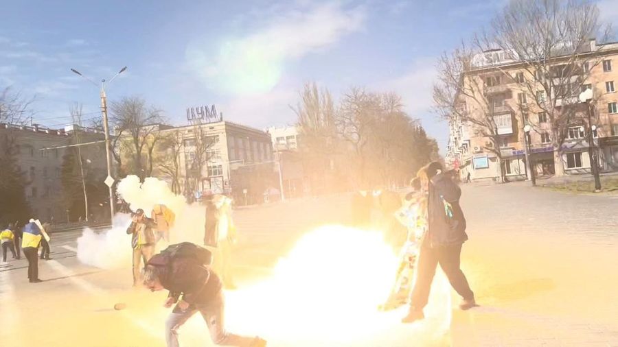 Demonstrators react to stun grenades thrown by Russian troops as they protest the Russian invasion, along Ushakova Avenue in Kherson, Ukraine March 21, 2022 in this still image from video obtained by REUTERS THIS IMAGE HAS BEEN SUPPLIED BY A THIRD PARTY. NO RESALES. NO ARCHIVES