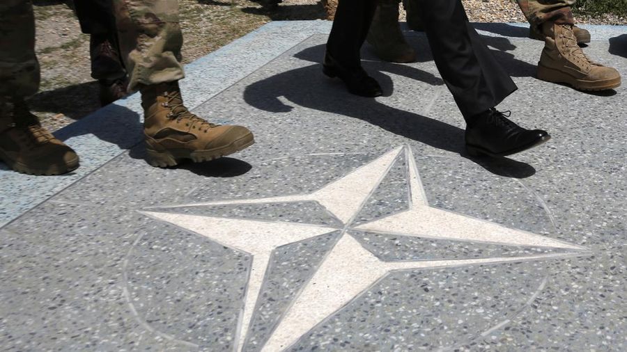 U.S. Defense Secretary James Mattis, in black dress shoes, walks with U.S. Army leaders across a NATO logo as he arrives at Resolute Support headquarters, in Kabul, Afghanistan Monday, April 24, 2017. (Jonathan Ernst/Pool Photo via AP)