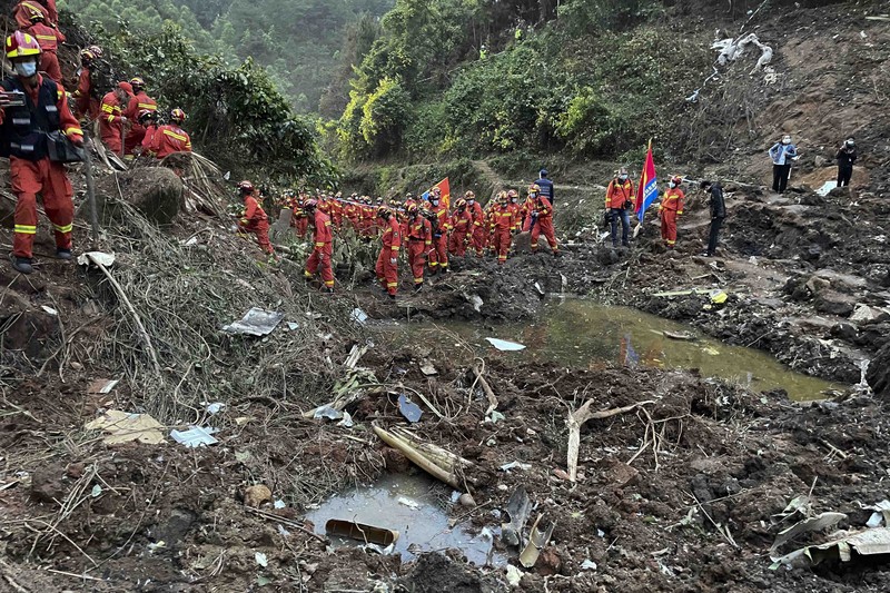 In this photo released by Xinhua News Agency, rescue workers search for the black boxes at a plane crash site in Tengxian county, southwestern China's Guangxi Zhuang Autonomous Region, Tuesday, March 22, 2022. A China Eastern flight 5735 carrying 123 passengers and nine crew members crashed outside the city of Wuzhou in the Guangxi region while flying from Kunming, the capital of the southwestern province of Yunnan, to Guangzhou, an industrial center not far from Hong Kong on China's southeastern coast. It ignited a fire big enough to be seen on NASA satellite images before firefighters could extinguished it. (Zhou Hua/Xinhua via AP)