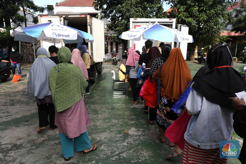 Warga antre untuk mendapatkan Program Pangan Bersubsidi (PPB) di RPTRA di kawasan Jakarta, Rabu (23/3/2022). Program Pangan Bersubsidi (PPB) tersebut kembali didistribusikan oleh Pemerintah Provinsi DKI Jakarta yang sebelumnya sudah dilaksanakan pada Februari 2022. (CNBC Indonesia/Tri Susilo)