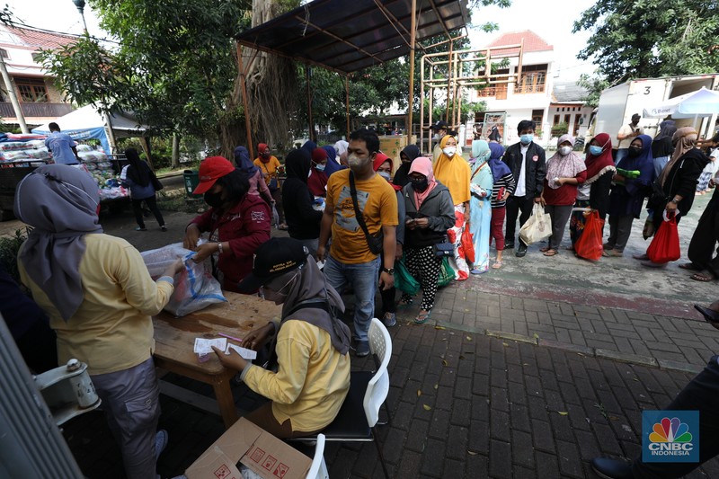 Warga antre untuk mendapatkan Program Pangan Bersubsidi (PPB) di RPTRA di kawasan Jakarta, Rabu (23/3/2022). Program Pangan Bersubsidi (PPB) tersebut kembali didistribusikan oleh Pemerintah Provinsi DKI Jakarta yang sebelumnya sudah dilaksanakan pada Februari 2022. (CNBC Indonesia/Tri Susilo)