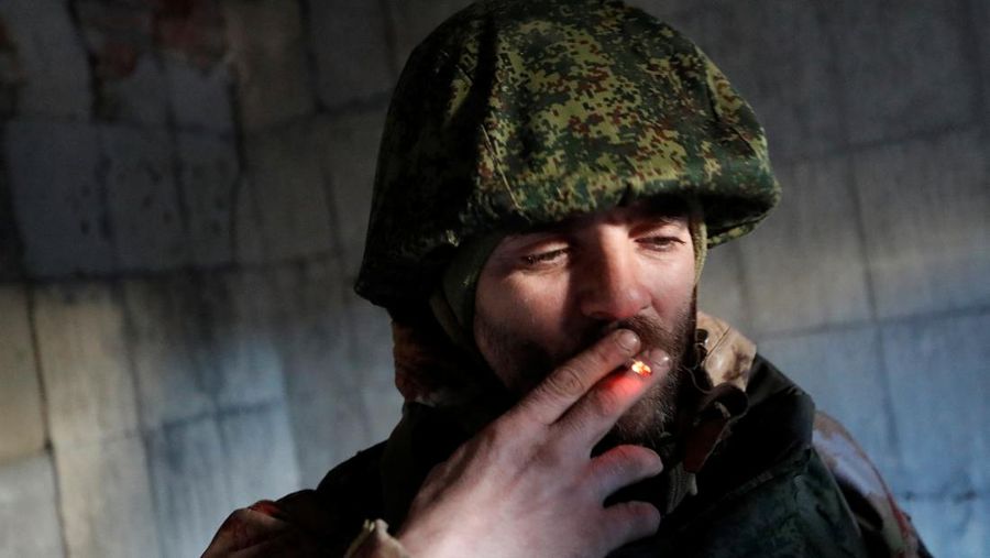 A service member of pro-Russian troops smokes inside a building, which according to the military, was previously a fighting position of Ukrainian armed forces, during Ukraine-Russia conflict in the town of Marinka, in the Donetsk Region, Ukraine March 22, 2022. REUTERS/Alexander Ermochenko