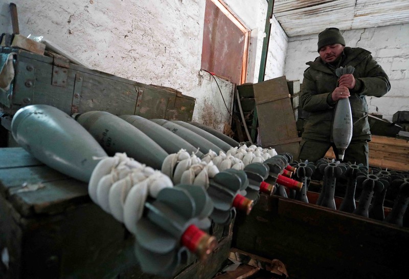 UKRAINE-CRISIS/DONETSK-REGION A service member of pro-Russian troops in uniform without insignia handles a mortar round at the weapons depot during Ukraine-Russia conflict near Marinka, in the Donetsk Region, Ukraine March 22, 2022. REUTERS/Alexander Ermochenko TPX IMAGES OF THE DAY