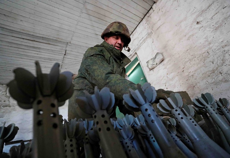 UKRAINE-CRISIS/DONETSK-REGION A service member of pro-Russian troops in uniform without insignia handles a mortar round at the weapons depot during Ukraine-Russia conflict near Marinka, in the Donetsk Region, Ukraine March 22, 2022. REUTERS/Alexander Ermochenko TPX IMAGES OF THE DAY