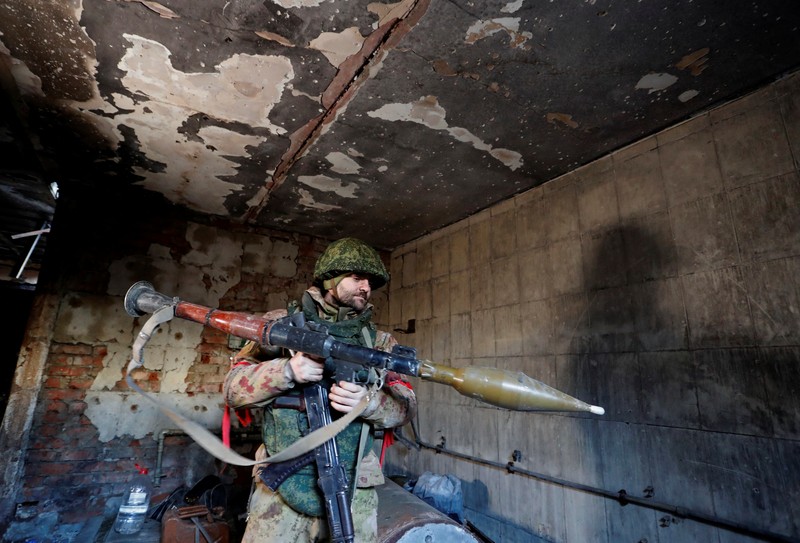 UKRAINE-CRISIS/DONETSK-REGION A service member of pro-Russian troops in uniform without insignia handles a mortar round at the weapons depot during Ukraine-Russia conflict near Marinka, in the Donetsk Region, Ukraine March 22, 2022. REUTERS/Alexander Ermochenko TPX IMAGES OF THE DAY