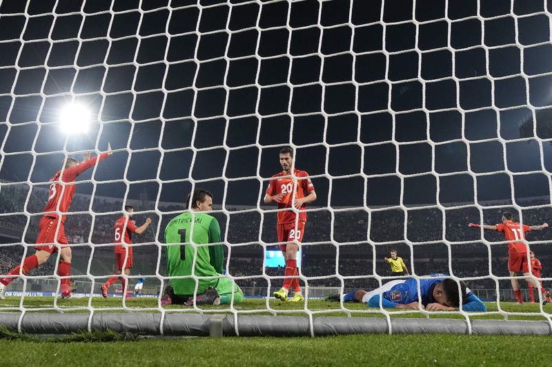 North Macedonia players celebrate as Italy's Alessandro Bastoni reacts after his team's got eliminated at the end of the World Cup qualifying play-off soccer match between Italy and North Macedonia, at Renzo Barbera stadium, in Palermo, Italy, Thursday, March 24, 2022. North Macedonia won 1-0. (AP Photo/Antonio Calanni)