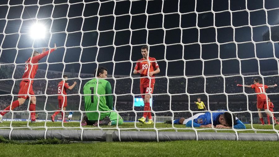 North Macedonia players celebrate as Italy's Alessandro Bastoni reacts after his team's got eliminated at the end of the World Cup qualifying play-off soccer match between Italy and North Macedonia, at Renzo Barbera stadium, in Palermo, Italy, Thursday, March 24, 2022. North Macedonia won 1-0. (AP Photo/Antonio Calanni)