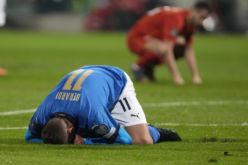 Italy North Macedonia WCup 2022 Soccer North Macedonia players celebrate as Italy's Alessandro Bastoni reacts after his team's got eliminated at the end of the World Cup qualifying play-off soccer match between Italy and North Macedonia, at Renzo Barbera stadium, in Palermo, Italy, Thursday, March 24, 2022. North Macedonia won 1-0. (AP Photo/Antonio Calanni)