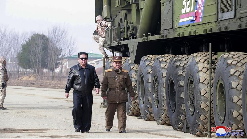 In this photo distributed by the North Korean government, North Korean leader Kim Jong Un, center, walks around what it says a Hwasong-17 intercontinental ballistic missile (ICBM) on the launcher, at an undisclosed location in North Korea on March 24, 2022. Independent journalists were not given access to cover the event depicted in this image distributed by the North Korean government. The content of this image is as provided and cannot be independently verified. Korean language watermark on image as provided by source reads: 