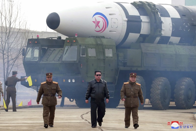 In this photo distributed by the North Korean government, North Korean leader Kim Jong Un, center, walks around what it says a Hwasong-17 intercontinental ballistic missile (ICBM) on the launcher, at an undisclosed location in North Korea on March 24, 2022. Independent journalists were not given access to cover the event depicted in this image distributed by the North Korean government. The content of this image is as provided and cannot be independently verified. Korean language watermark on image as provided by source reads: 