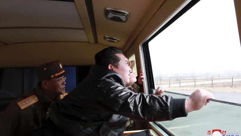 In this photo distributed by the North Korean government, North Korean leader Kim Jong Un, center, walks around what it says a Hwasong-17 intercontinental ballistic missile (ICBM) on the launcher, at an undisclosed location in North Korea on March 24, 2022. Independent journalists were not given access to cover the event depicted in this image distributed by the North Korean government. The content of this image is as provided and cannot be independently verified. Korean language watermark on image as provided by source reads: 