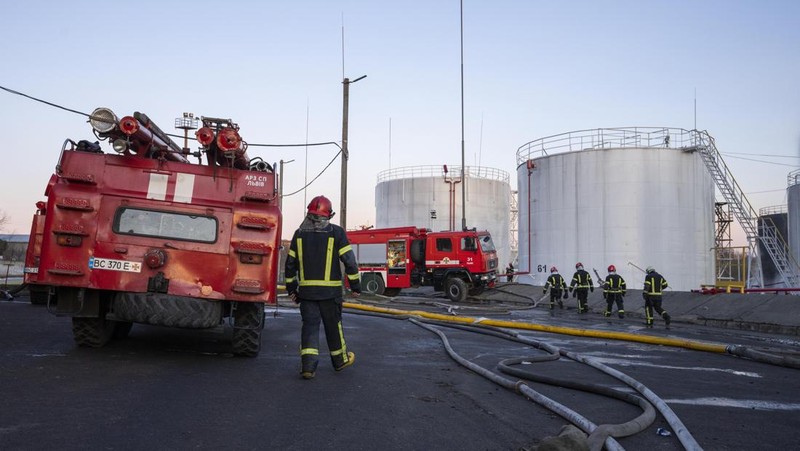 Petugas pemadam kebakaran bekerja di lokasi setelah serangan udara roket Rusia yang menghantam fasilitas minyak di kawasan industri di pinggiran timur laut Lviv, Ukraina, Minggu, (27/3/2022). (AP Photo/Nariman El-Mofty)