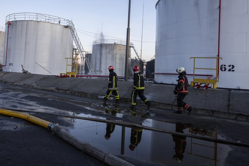 Petugas pemadam kebakaran bekerja di lokasi setelah serangan udara roket Rusia yang menghantam fasilitas minyak di kawasan industri di pinggiran timur laut Lviv, Ukraina, Minggu, (27/3/2022). (AP Photo/Nariman El-Mofty)