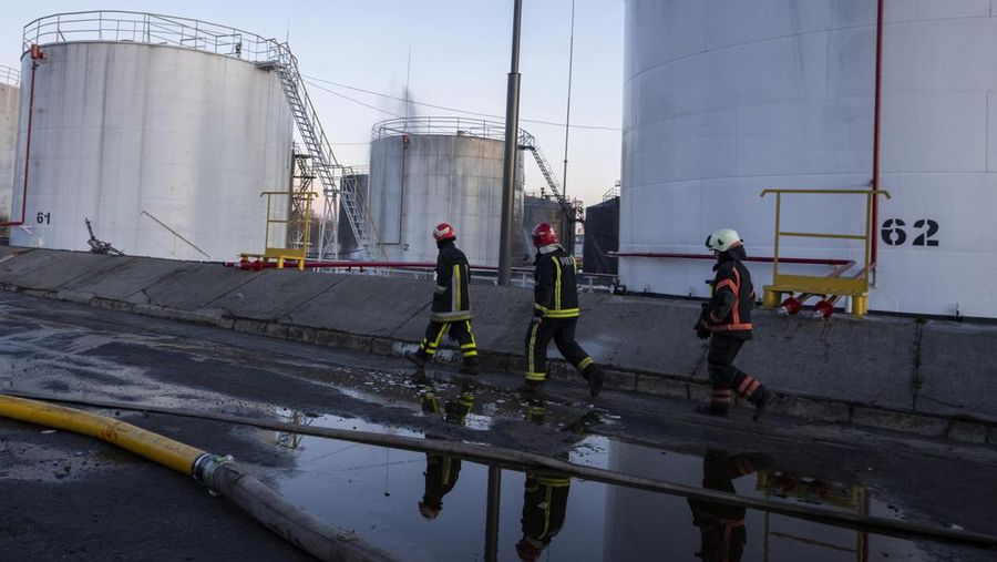 Petugas pemadam kebakaran bekerja di lokasi setelah serangan udara roket Rusia yang menghantam fasilitas minyak di kawasan industri di pinggiran timur laut Lviv, Ukraina, Minggu, (27/3/2022). (AP Photo/Nariman El-Mofty)