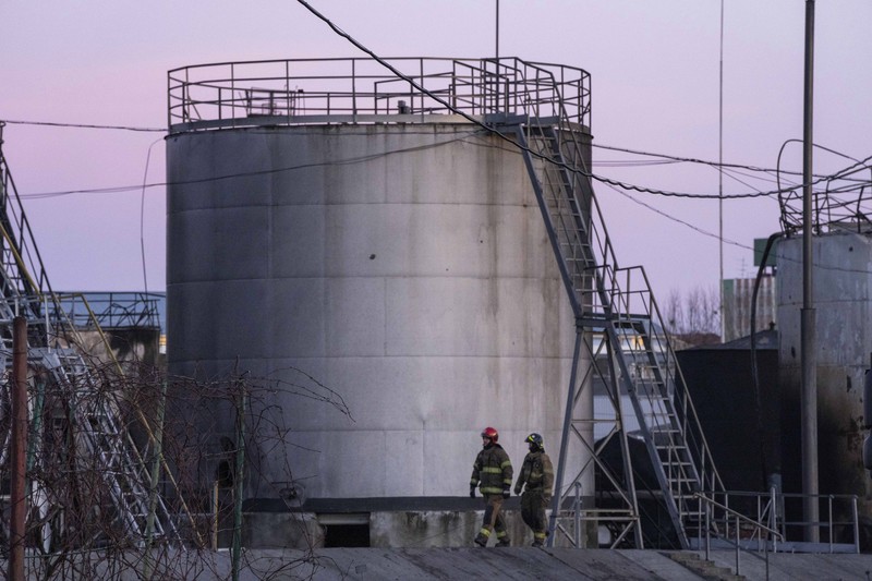 Petugas pemadam kebakaran bekerja di lokasi setelah serangan udara roket Rusia yang menghantam fasilitas minyak di kawasan industri di pinggiran timur laut Lviv, Ukraina, Minggu, (27/3/2022). (AP Photo/Nariman El-Mofty)