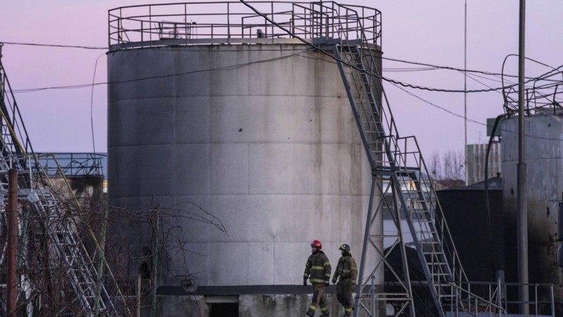 Petugas pemadam kebakaran bekerja di lokasi setelah serangan udara roket Rusia yang menghantam fasilitas minyak di kawasan industri di pinggiran timur laut Lviv, Ukraina, Minggu, (27/3/2022). (AP Photo/Nariman El-Mofty)