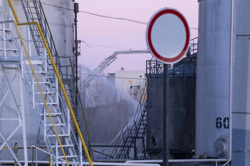Petugas pemadam kebakaran bekerja di lokasi setelah serangan udara roket Rusia yang menghantam fasilitas minyak di kawasan industri di pinggiran timur laut Lviv, Ukraina, Minggu, (27/3/2022). (AP Photo/Nariman El-Mofty)