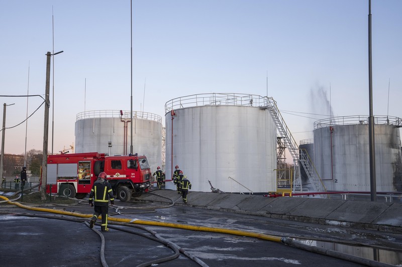 Petugas pemadam kebakaran bekerja di lokasi setelah serangan udara roket Rusia yang menghantam fasilitas minyak di kawasan industri di pinggiran timur laut Lviv, Ukraina, Minggu, (27/3/2022). (AP Photo/Nariman El-Mofty)