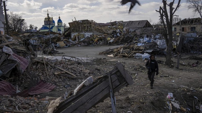 Seorang prajurit Ukraina berjalan di luar gedung administrasi regional, yang rusak berat setelah serangan Rusia awal bulan ini di Kharkiv, Ukraina, Minggu (27/3/2022). (AP Photo/Felipe Dana)