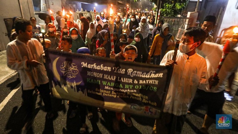 Sejumlah warga mengikuti pawai obor di kawasan Matraman Dalam, Jakarta, Minggu (27/3/2022). Pawai obor tersebut dalam rangka menyambut bulan suci Ramadhan 1443 Hijriah. (CNBC Indonesia/ Andrean Kristianto)