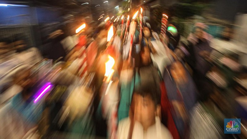 Sejumlah warga mengikuti pawai obor di kawasan Matraman Dalam, Jakarta, Minggu (27/3/2022). Pawai obor tersebut dalam rangka menyambut bulan suci Ramadhan 1443 Hijriah. (CNBC Indonesia/ Andrean Kristianto)