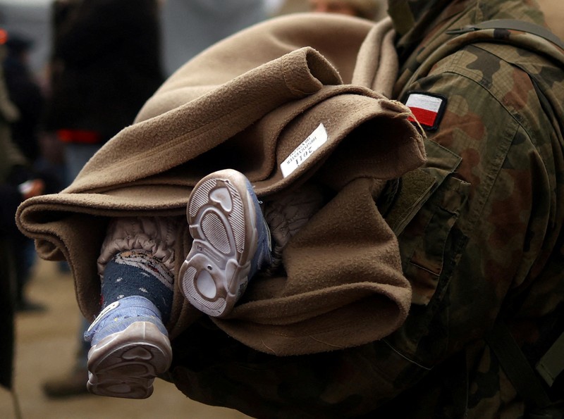 Seorang prajurit Ukraina berjalan di luar gedung administrasi regional, yang rusak berat setelah serangan Rusia awal bulan ini di Kharkiv, Ukraina, Minggu (27/3/2022). (AP Photo/Felipe Dana)