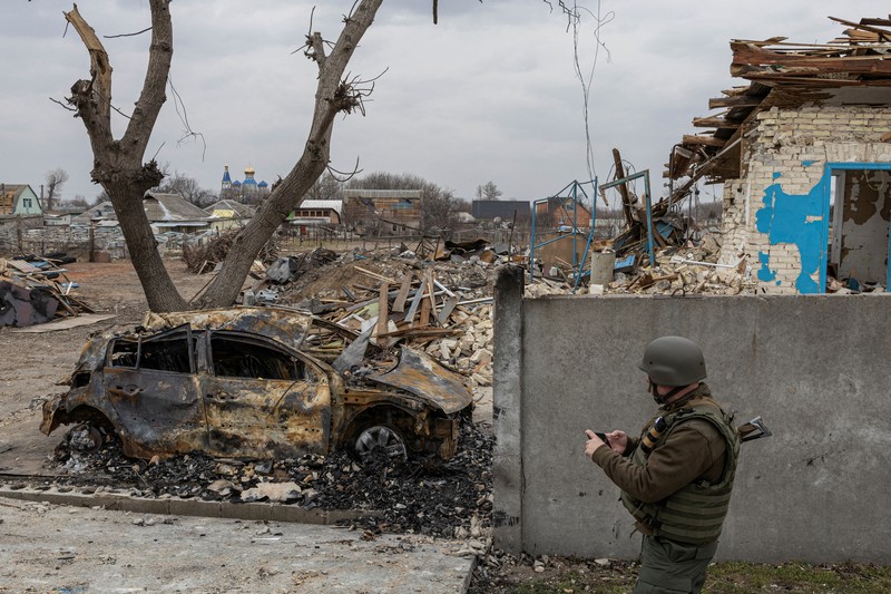 Seorang prajurit Ukraina berjalan di luar gedung administrasi regional, yang rusak berat setelah serangan Rusia awal bulan ini di Kharkiv, Ukraina, Minggu (27/3/2022). (AP Photo/Felipe Dana)