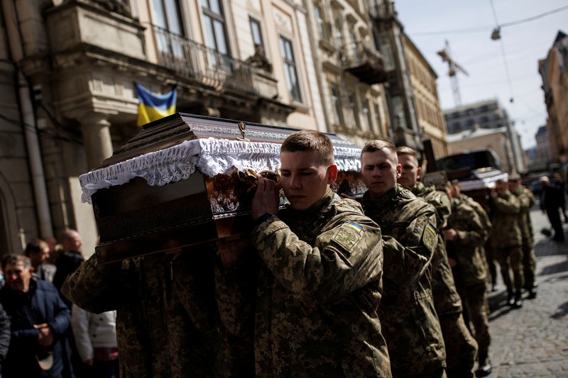 Seorang prajurit Ukraina berjalan di luar gedung administrasi regional, yang rusak berat setelah serangan Rusia awal bulan ini di Kharkiv, Ukraina, Minggu (27/3/2022). (AP Photo/Felipe Dana)