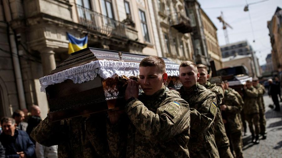 Seorang prajurit Ukraina berjalan di luar gedung administrasi regional, yang rusak berat setelah serangan Rusia awal bulan ini di Kharkiv, Ukraina, Minggu (27/3/2022). (AP Photo/Felipe Dana)