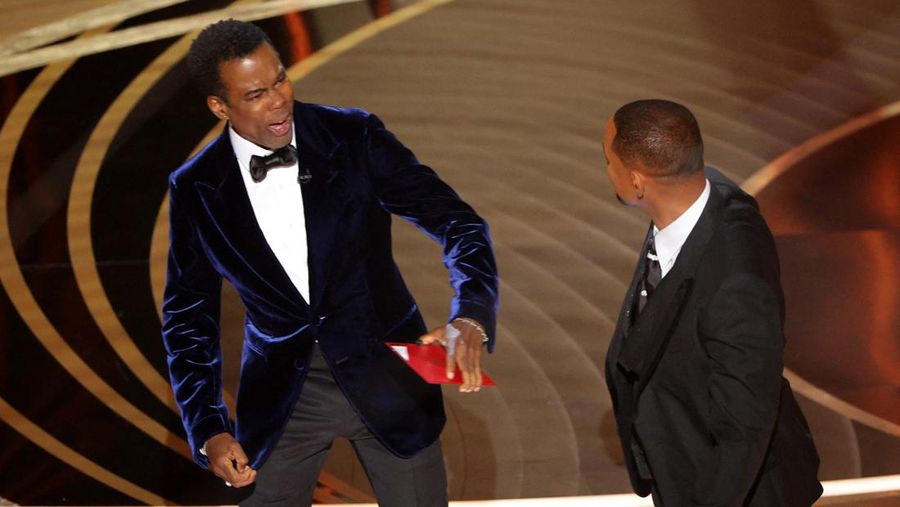 Will Smith (kanan) memukul Chris Rock saat Rock berbicara di atas panggung selama Academy Awards ke-94 di Hollywood, Los Angeles, California, AS, Minggu (27/3/2022). (REUTERS/Brian Snyder)