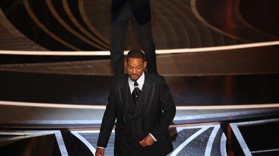 Will Smith berjalan di atas panggung setelah memukul Chris Rock saat Rock berbicara di atas panggung selama Awards ke-94 di Hollywood, Los Angeles, California, AS, Minggu (27/3/2022). (REUTERS/Brian Snyder)