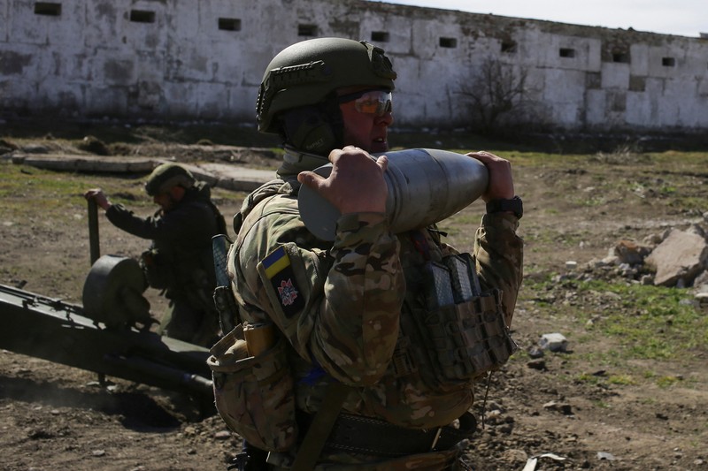 Seorang anggota Korps Relawan Ukraina menembak dengan howitzer saat serangan Rusia ke Ukraina A member of the Ukrainian Volunteer Corps fires with a howitzer, as Russia's attack on Ukraine continues, at a position in Zaporizhzhia region, Ukraine March 28, 2022. Picture taken March 28, 2022. REUTERS/Stanislav Yurchenko
