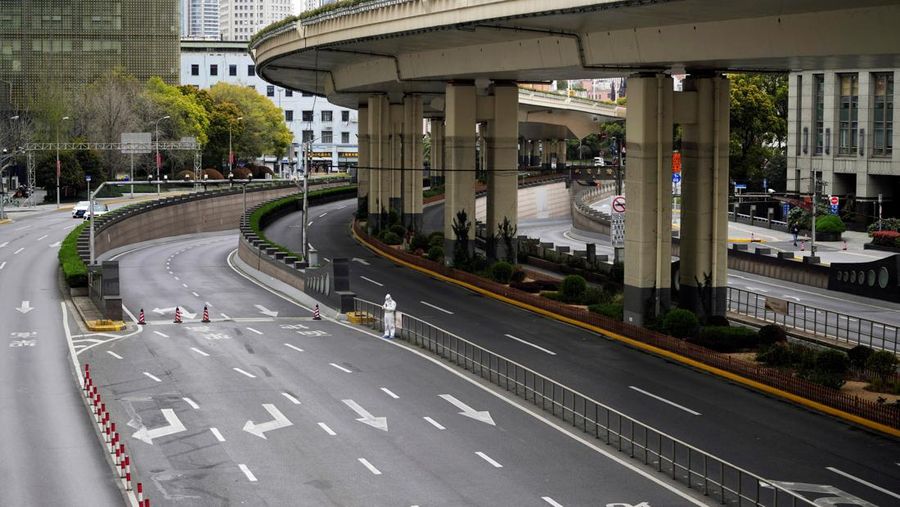 Seorang pekerja dengan pakaian pelindung berdiri di dekat pintu keluar terowongan yang mengarah ke daerah Pudong di seberang sungai Huangpu, saat penguncian atau lockdown secara bertahap akibat penyebaran Covid-19 di Shanghai, China, Minggu (28/3/2022) (REUTERS/Aly Song)
