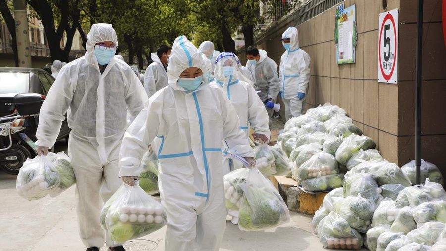 Polisi lalu lintas yang mengenakan pakaian pelindung memeriksa kendaraan sebelum terowongan underpass yang ditutup menyusul penyebaran Covid-19 di Shanghai, China, Senin (28/3/2022).  (Chinatopix Via AP)