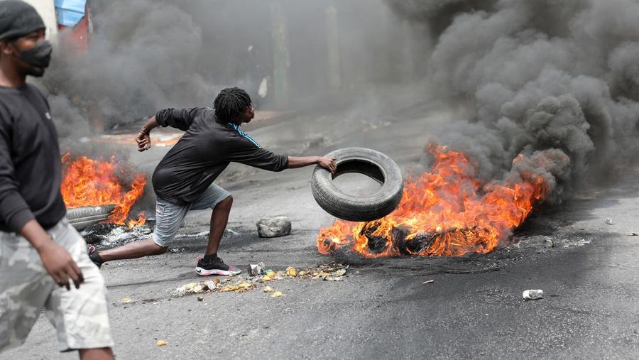 Sebuah pesawat milik kelompok misionaris AS Agape Flights terbakar setelah dibakar selama protes menuntut pemerintah Perdana Menteri Ariel Henry berbuat lebih banyak untuk mengatasi kekerasan geng termasuk penculikan terus-menerus, di Port-au-Prince, Haiti, Selasa (29/3/2022).  (REUTERS/Duples Plymouth)