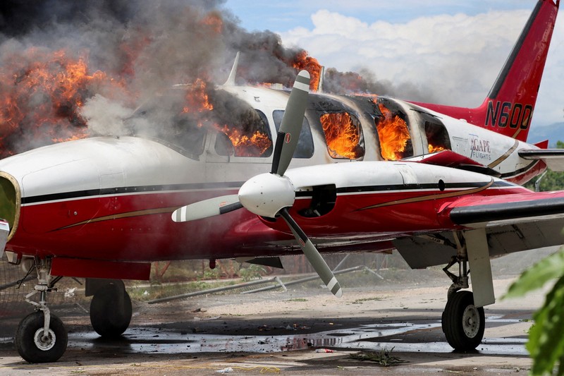 Sebuah pesawat milik kelompok misionaris AS Agape Flights terbakar setelah dibakar selama protes menuntut pemerintah Perdana Menteri Ariel Henry berbuat lebih banyak untuk mengatasi kekerasan geng termasuk penculikan terus-menerus, di Port-au-Prince, Haiti, Selasa (29/3/2022).  (REUTERS/Duples Plymouth)