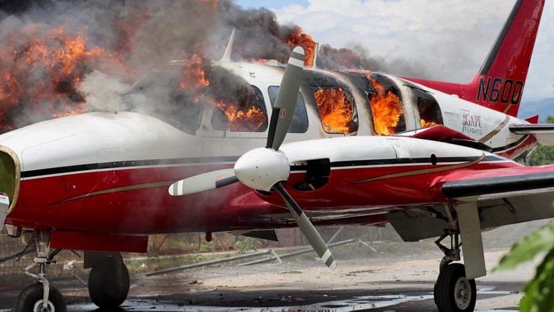 Sebuah pesawat milik kelompok misionaris AS Agape Flights terbakar setelah dibakar selama protes menuntut pemerintah Perdana Menteri Ariel Henry berbuat lebih banyak untuk mengatasi kekerasan geng termasuk penculikan terus-menerus, di Port-au-Prince, Haiti, Selasa (29/3/2022).  (REUTERS/Duples Plymouth)