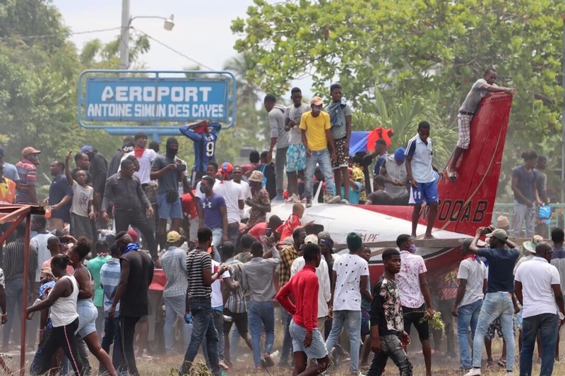Sebuah pesawat milik kelompok misionaris AS Agape Flights terbakar setelah dibakar selama protes menuntut pemerintah Perdana Menteri Ariel Henry berbuat lebih banyak untuk mengatasi kekerasan geng termasuk penculikan terus-menerus, di Port-au-Prince, Haiti, Selasa (29/3/2022).  (REUTERS/Duples Plymouth)
