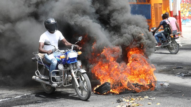Sebuah pesawat milik kelompok misionaris AS Agape Flights terbakar setelah dibakar selama protes menuntut pemerintah Perdana Menteri Ariel Henry berbuat lebih banyak untuk mengatasi kekerasan geng termasuk penculikan terus-menerus, di Port-au-Prince, Haiti, Selasa (29/3/2022).  (REUTERS/Duples Plymouth)
