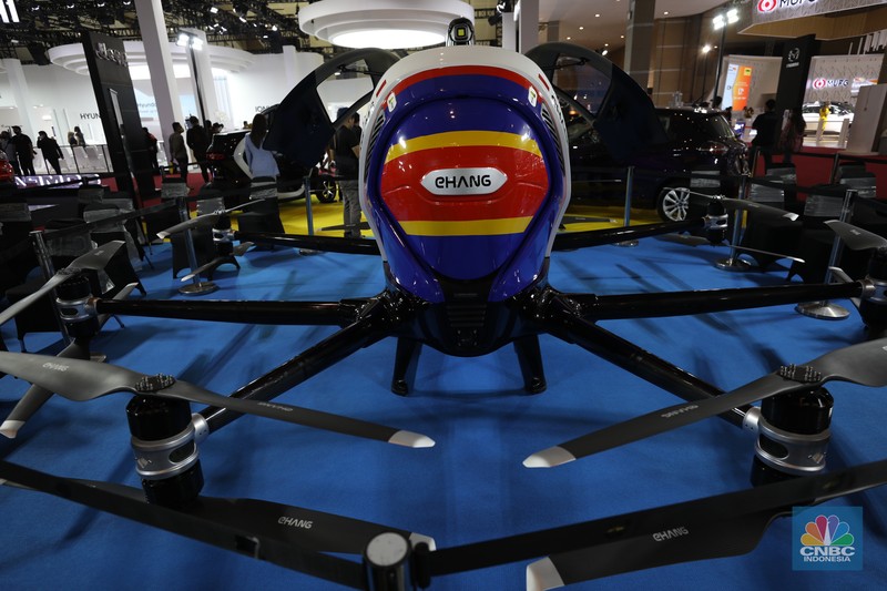 Model berpose di depan taksi terbang EHang yang dipamerkan di ajang Indonesia Internasional Motor Show (IIMS) Jakarta, Kamis (31/3/2022). Taksi terbang EHang merupakan kendaraan udara otonom (autonomous aerial vehicle) kelas penumpang berbasis listrik. (CNBC Indonesia/ Tri Susilo)