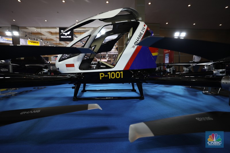 Model berpose di depan taksi terbang EHang yang dipamerkan di ajang Indonesia Internasional Motor Show (IIMS) Jakarta, Kamis (31/3/2022). Taksi terbang EHang merupakan kendaraan udara otonom (autonomous aerial vehicle) kelas penumpang berbasis listrik. (CNBC Indonesia/ Tri Susilo)