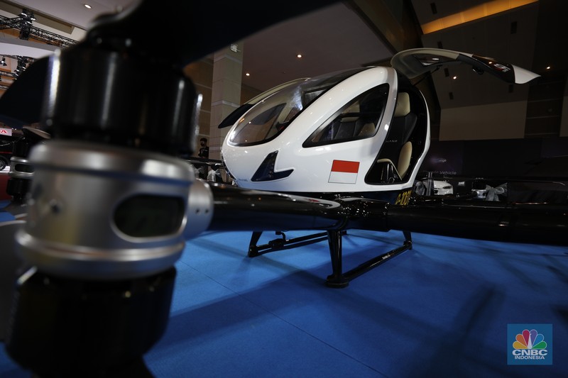 Taksi terbang EHang 216 di IIMS 2022 Model berpose di depan taksi terbang EHang yang dipamerkan di ajang Indonesia Internasional Motor Show (IIMS) Jakarta, Kamis (31/3/2022). Taksi terbang EHang merupakan kendaraan udara otonom (autonomous aerial vehicle) kelas penumpang berbasis listrik. (CNBC Indonesia/ Tri Susilo)