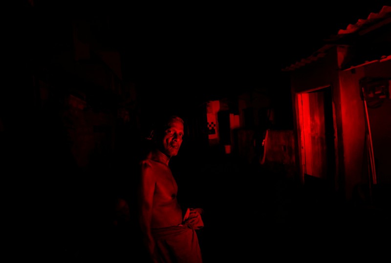 Pemadaman Listrik di Sri Lanka Seorang wanita bekerja di dalam sebuah toko yang terhubung dengan rumahnya selama pemadaman listrik di Kolombo, Sri Lanka, Rabu (30/3/2022). (REUTERS/Dinuka Liyanawatte)