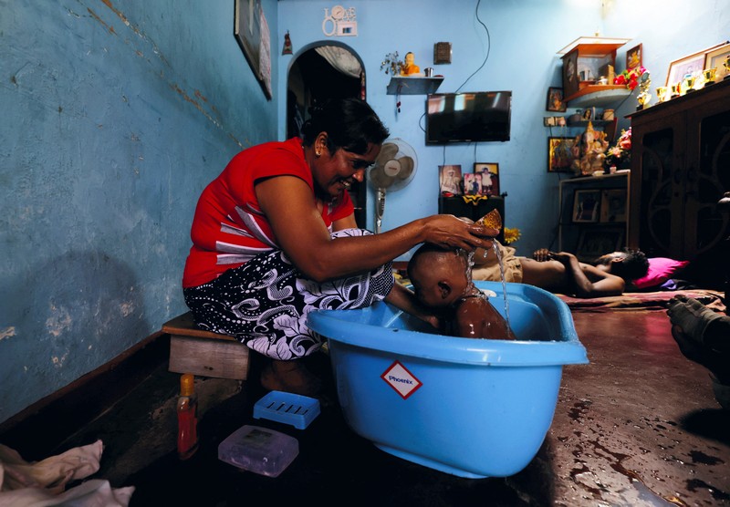 Pemadaman Listrik di Sri Lanka Seorang wanita bekerja di dalam sebuah toko yang terhubung dengan rumahnya selama pemadaman listrik di Kolombo, Sri Lanka, Rabu (30/3/2022). (REUTERS/Dinuka Liyanawatte)