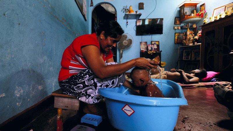 Seorang wanita bekerja di dalam sebuah toko yang terhubung dengan rumahnya selama pemadaman listrik di Kolombo, Sri Lanka, Rabu (30/3/2022). (REUTERS/Dinuka Liyanawatte)