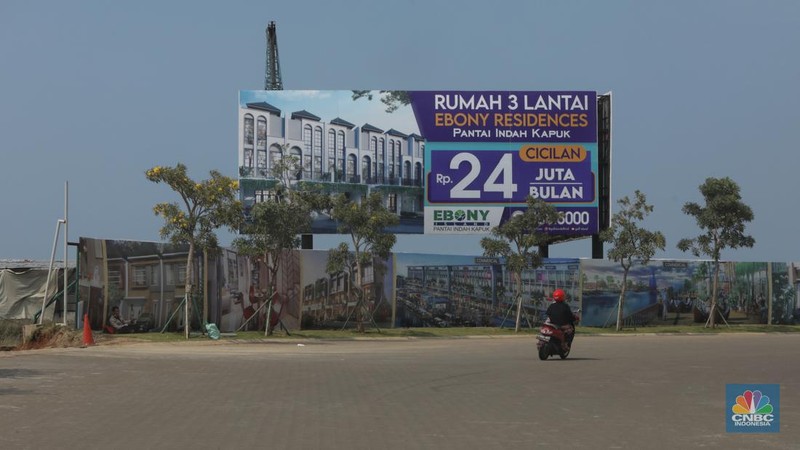 Kendaraan melintas di depan reklame di kawasan Pantai Indah Kapuk (PIK) 2, Selasa (5/3/2022). (CNBC Indonesia/Andrean Kristianto)