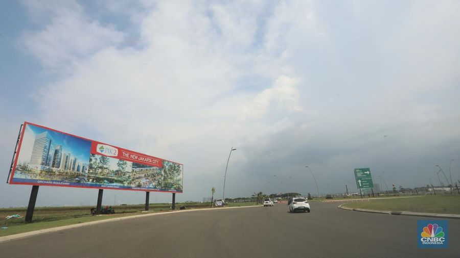 Kendaraan melintas di depan reklame di kawasan Pantai Indah Kapuk (PIK) 2, Selasa (5/3/2022). (CNBC Indonesia/Andrean Kristianto)