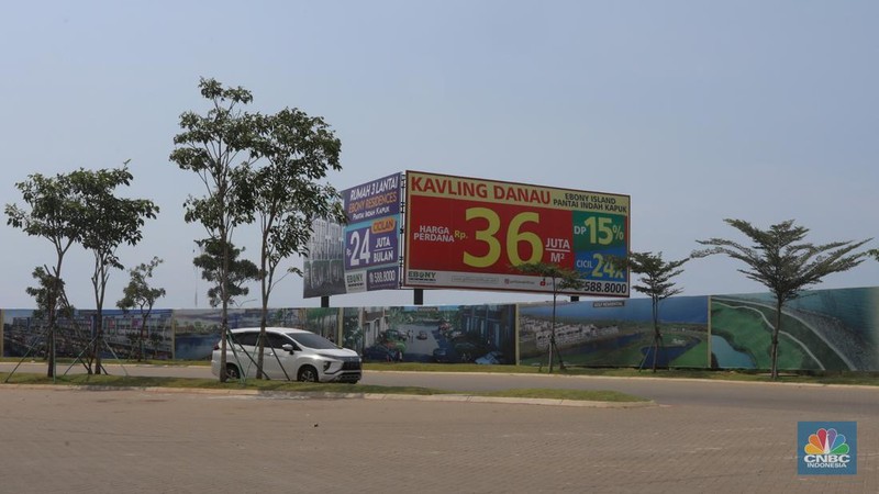 Kendaraan melintas di depan reklame di kawasan Pantai Indah Kapuk (PIK) 2, Selasa (5/3/2022). (CNBC Indonesia/Andrean Kristianto)