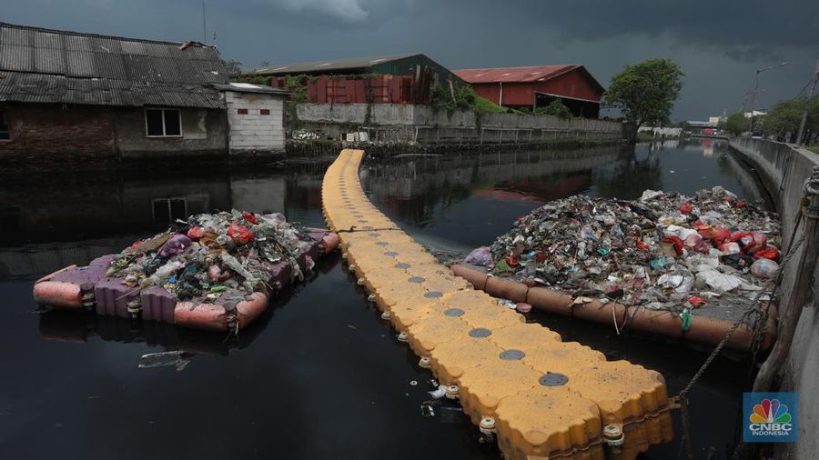 Kendaraan melintas di samping kali yang berwarna hitam di Kamal Muara, Jakarta Utara, Selasa (5/3/2022). (CNBC Indonesia/Andrean Kristianto)